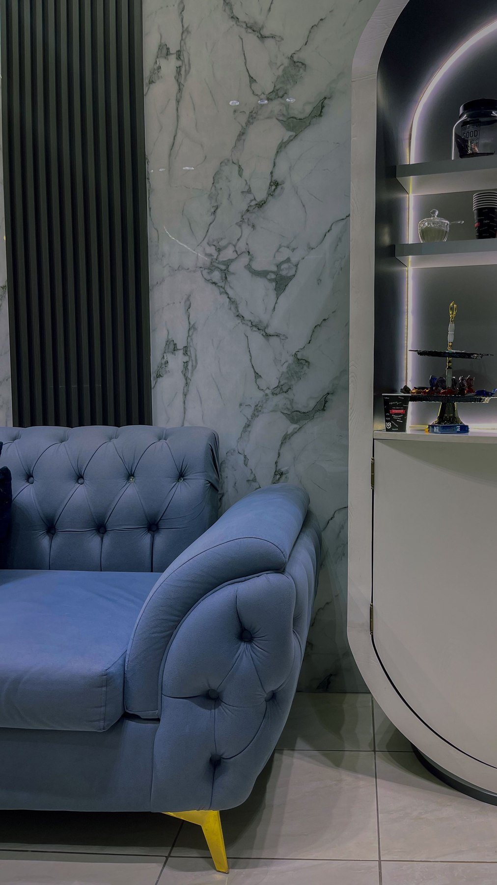 Living — Blue tufted armchair marble wall — Maitri Interior Studio project photo